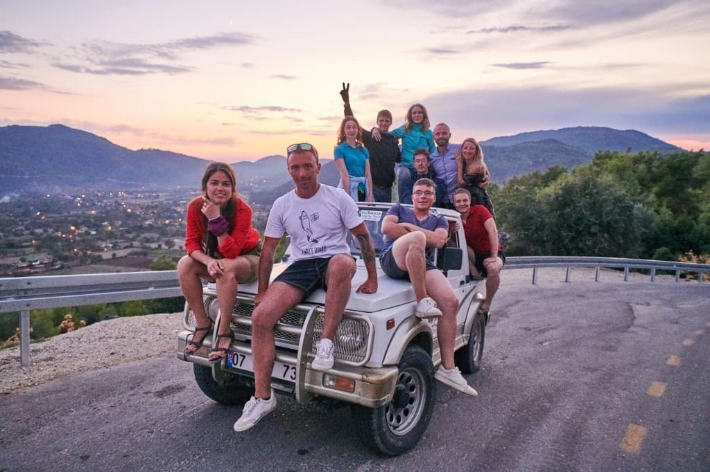 Camp group on a jeep at sunset